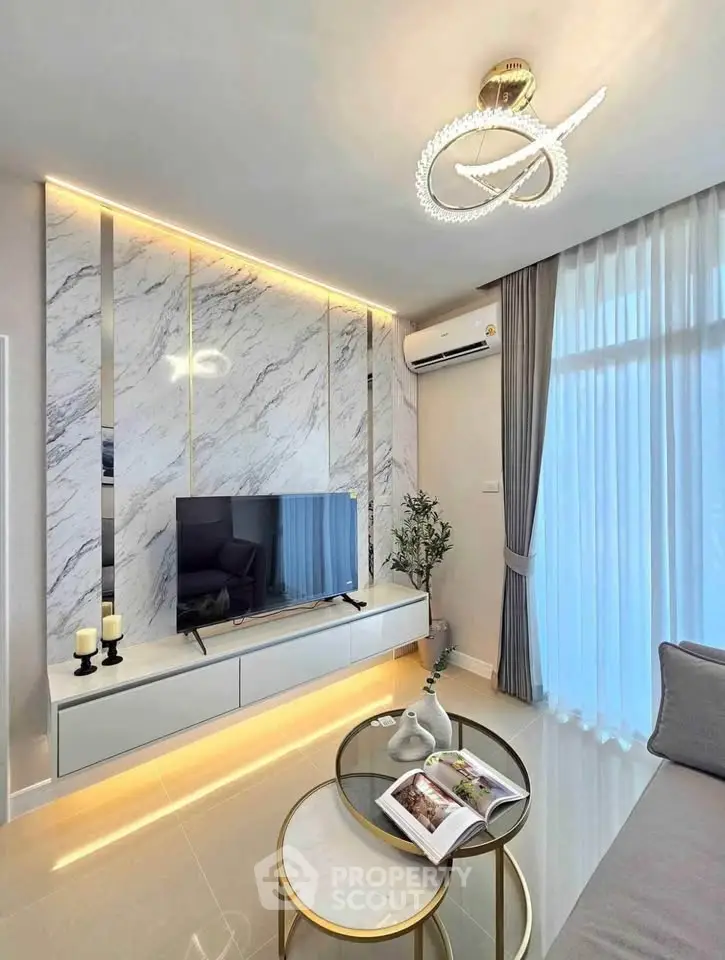 Modern living room with elegant decor, marble accent wall, and stylish lighting