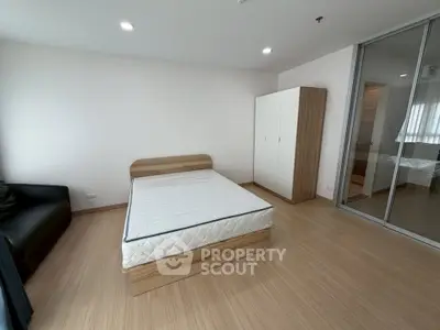 Spacious bedroom with modern wooden flooring and ample natural light