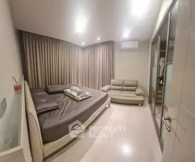 Spacious modern bedroom with cozy sofa and elegant lighting