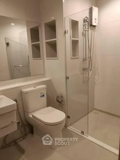 Modern bathroom with glass shower and sleek fixtures in a contemporary apartment.