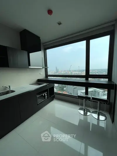 Modern kitchen with stunning city view, featuring sleek cabinetry and breakfast bar seating.