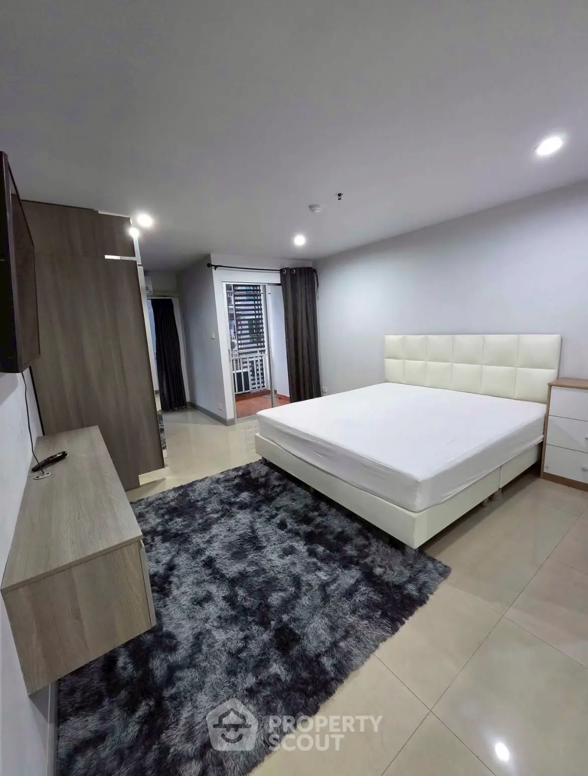 Spacious modern bedroom with sleek furniture and plush rug