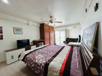 Spacious bedroom with modern decor and balcony access in a stylish apartment.