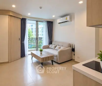 Modern living room with balcony view and sleek furniture in a stylish apartment.