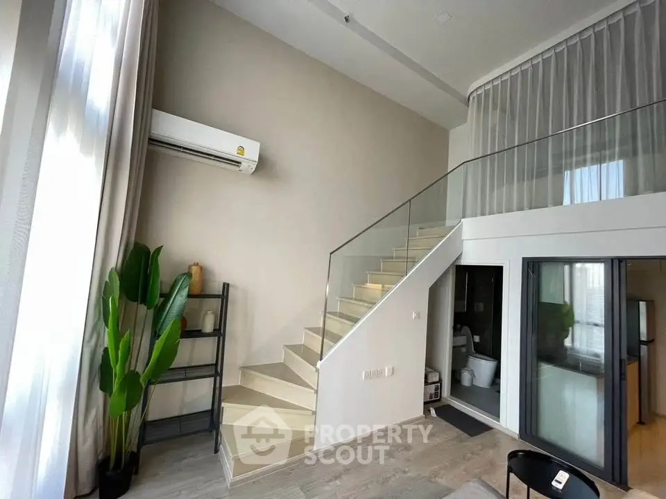 Modern duplex living room with high ceilings and stylish staircase