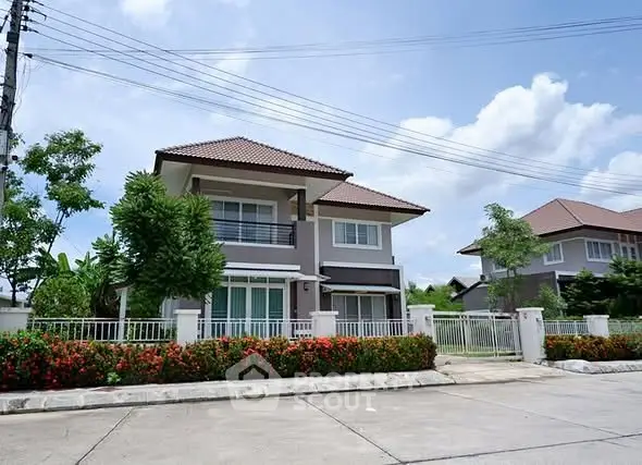 Charming two-story house with lush garden and modern architecture in a serene neighborhood.