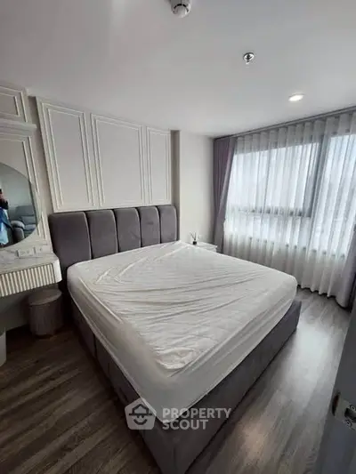 Modern bedroom with stylish decor and large window for natural light