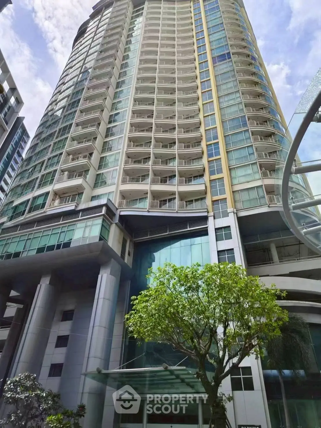 Stunning high-rise building with modern architecture and lush greenery, perfect for urban living.