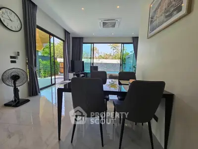 Modern living room with pool view and elegant dining area