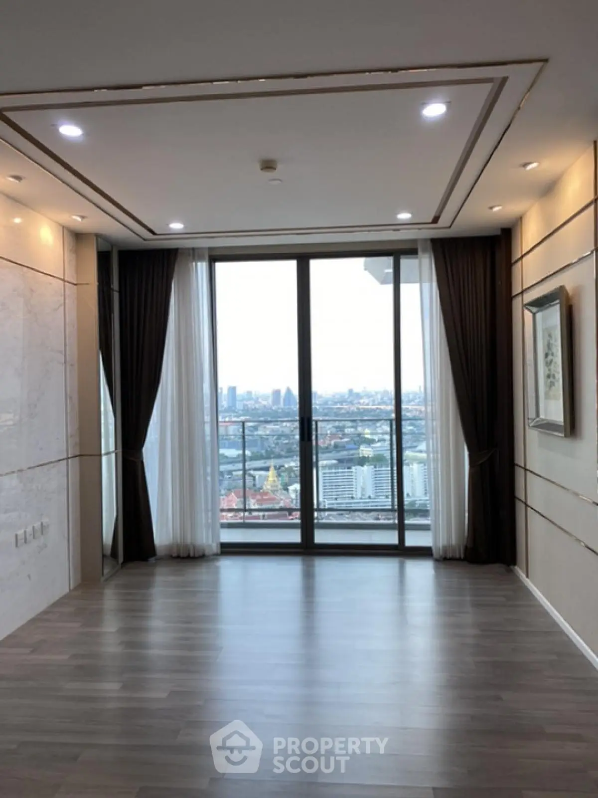 Spacious modern living room with floor-to-ceiling windows and city view