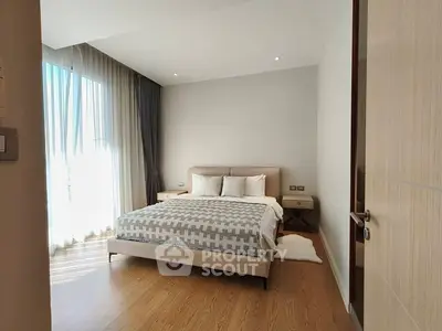 Spacious bedroom with modern decor and large windows for natural light