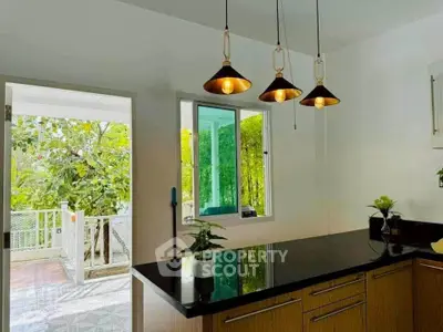 Modern kitchen with stylish pendant lights and garden view