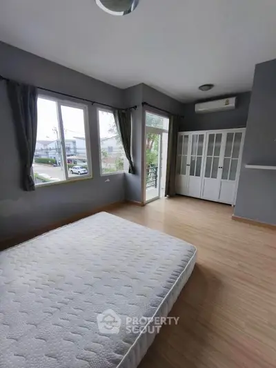 Spacious bedroom with large windows and balcony access in modern home