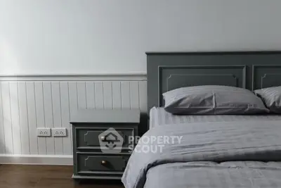 Cozy bedroom with elegant gray headboard and matching nightstand, perfect for a serene retreat.