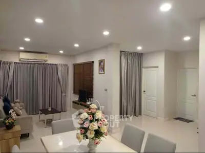 Elegant living room with modern decor and ambient lighting, featuring a cozy dining area and stylish furnishings.