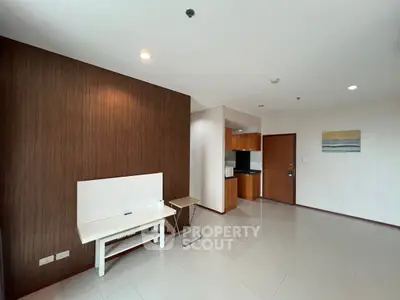 Spacious modern living area with sleek design and wooden accents.