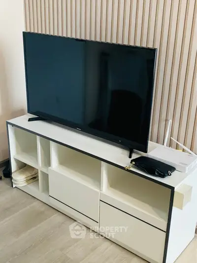 Modern living room with sleek TV stand and flat-screen television, perfect for entertainment.