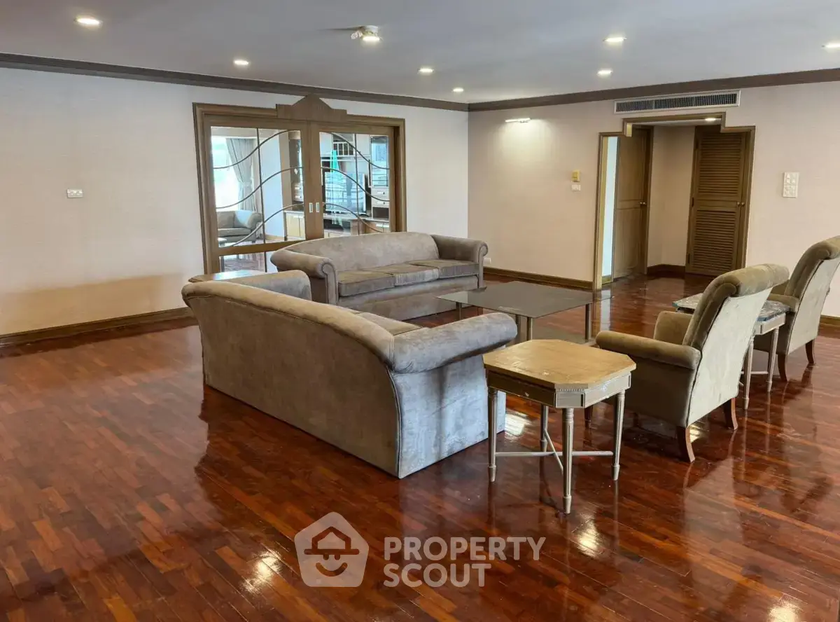 Spacious living room with elegant wooden flooring and comfortable seating in a luxurious apartment.