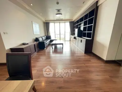 Spacious modern living room with wooden flooring and large windows for natural light.