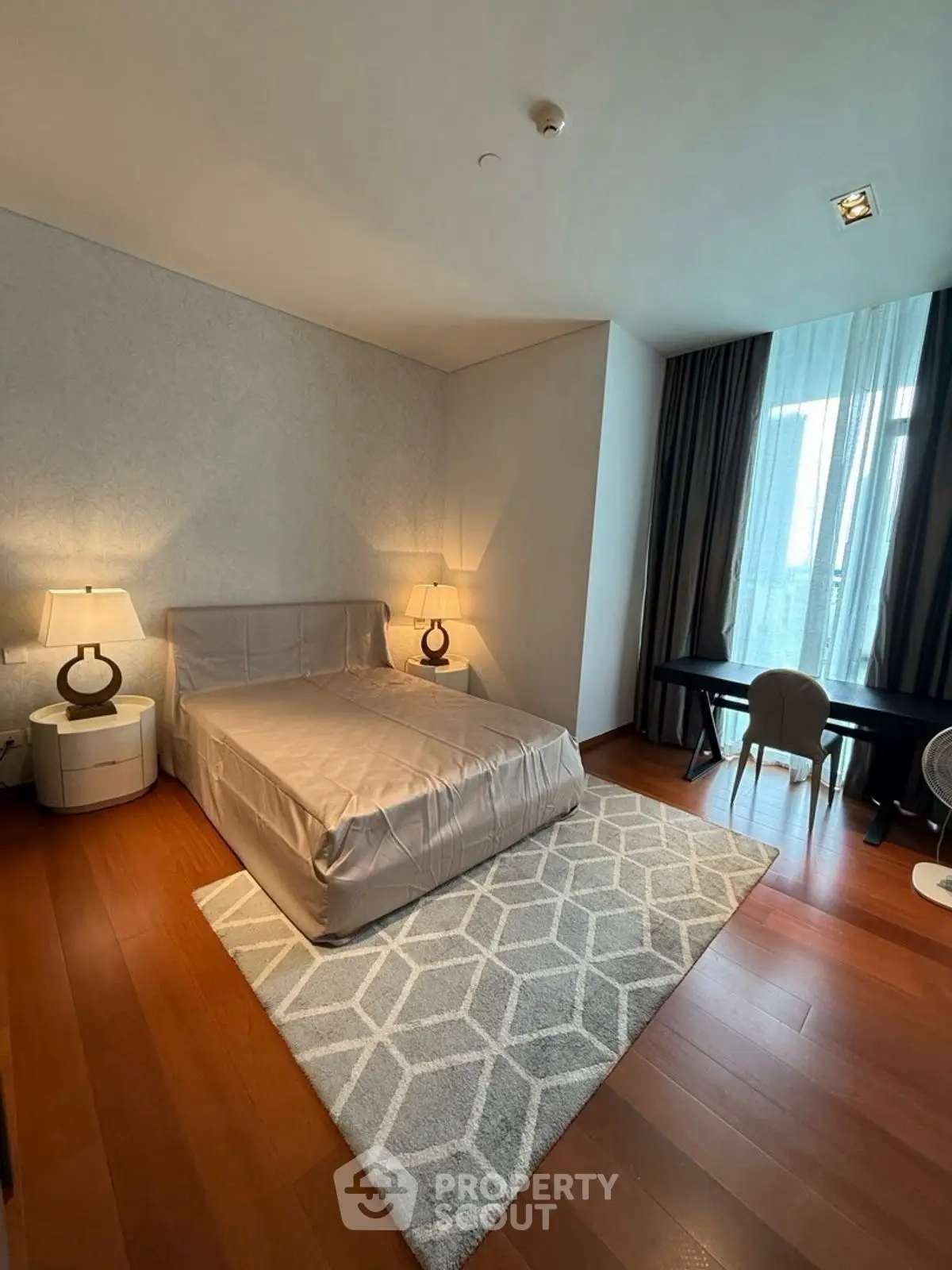 Elegant bedroom with modern decor, featuring a cozy bed, stylish lamps, and a chic desk by the window.