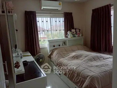 Cozy bedroom with plush toys, air conditioning, and natural light from window.