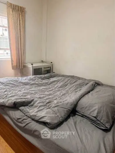 Cozy bedroom with a comfortable bed and natural light from the window, perfect for relaxation.