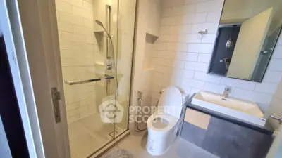 Modern bathroom with glass shower and sleek fixtures in a contemporary apartment.