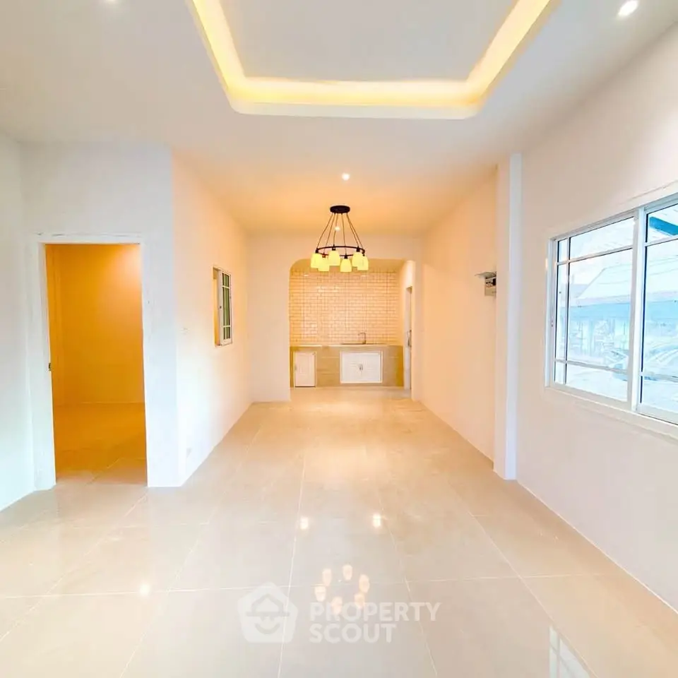 Spacious open-plan living area with modern lighting and tiled flooring