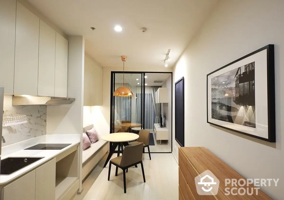 Elegant compact urban apartment with a seamless open layout connecting a modern kitchen to a cozy living space, featuring stylish furnishings and warm lighting.