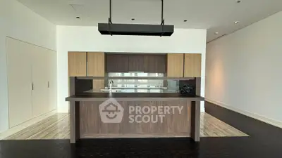 Modern kitchen with sleek wooden cabinetry and open layout in luxury apartment.
