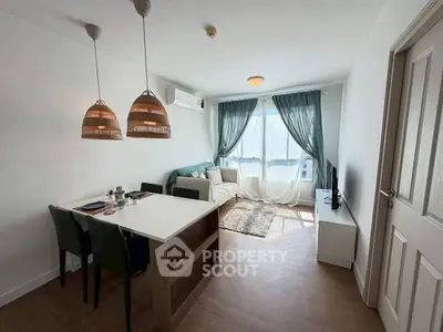 Charming living room with natural light, cozy seating, and stylish dining area in modern apartment.