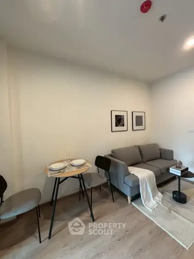 Cozy living room with modern sofa and dining area, perfect for relaxation and entertaining.