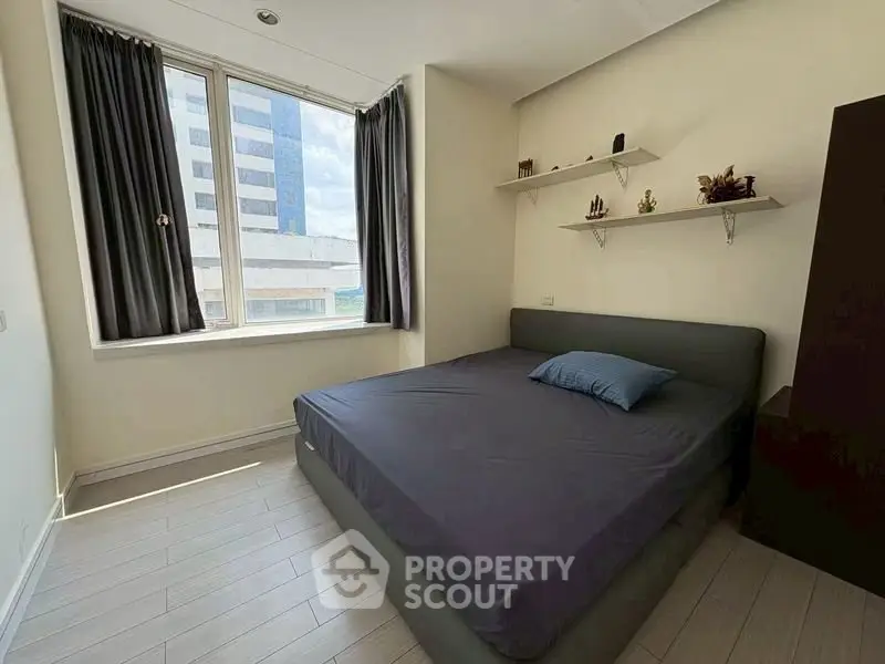 Cozy bedroom with large window and modern decor in urban apartment