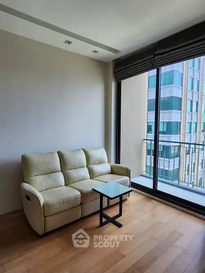 Modern living room with cozy sofa and large window offering city view