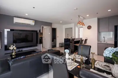 Modern open-plan living room with sleek kitchen and stylish decor in a contemporary apartment.