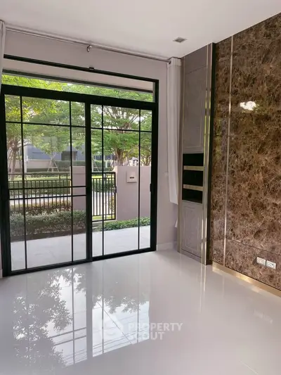Elegant modern living room with large glass doors and marble accent wall