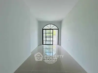 Spacious empty room with large window and glossy tiled floor, perfect for customization.