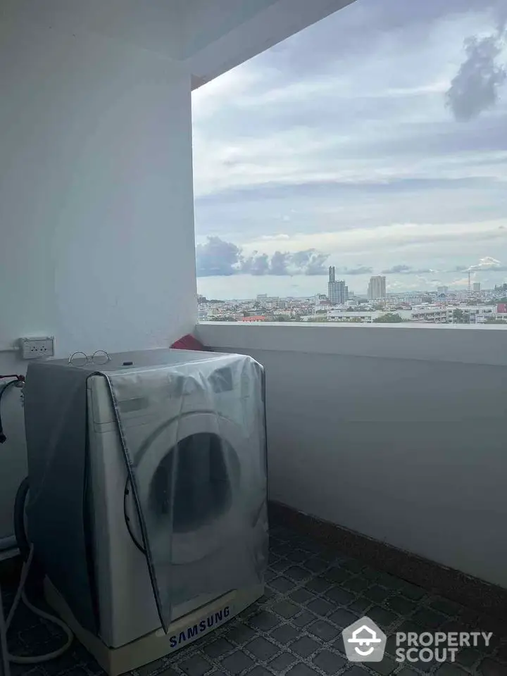 High-rise balcony with washing machine and stunning cityscape view