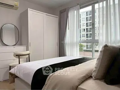 Modern bedroom with large window and stylish decor in urban apartment