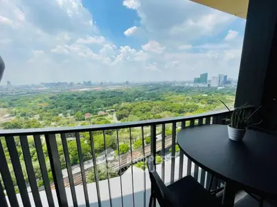 Stunning balcony view overlooking lush greenery and city skyline, perfect for relaxation and enjoying nature.