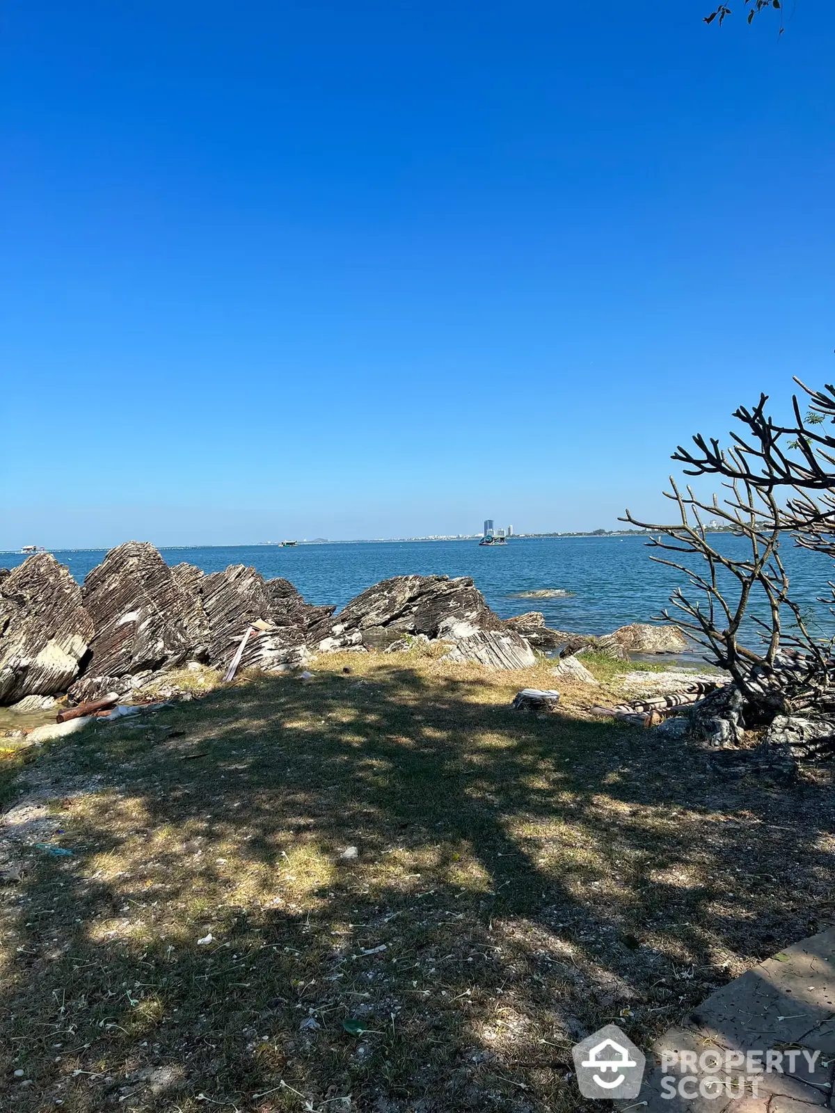 Breathtaking waterfront view from a serene property, showcasing clear blue skies and tranquil waters, perfect for a peaceful living experience.