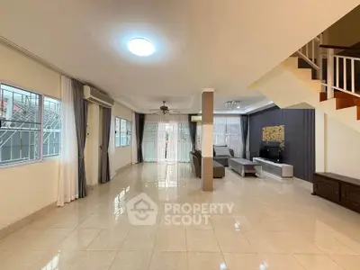 Spacious living room with modern decor and natural light, perfect for family gatherings.