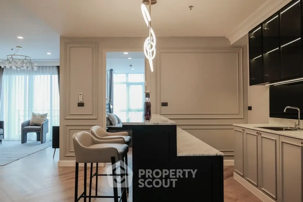 Luxurious modern kitchen with elegant lighting and open layout, featuring sleek cabinetry and stylish bar seating.