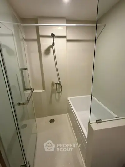 Modern bathroom with glass shower and bathtub in sleek apartment