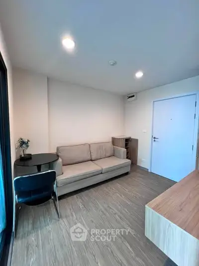 Modern living room with cozy sofa and sleek wooden flooring in a stylish apartment.