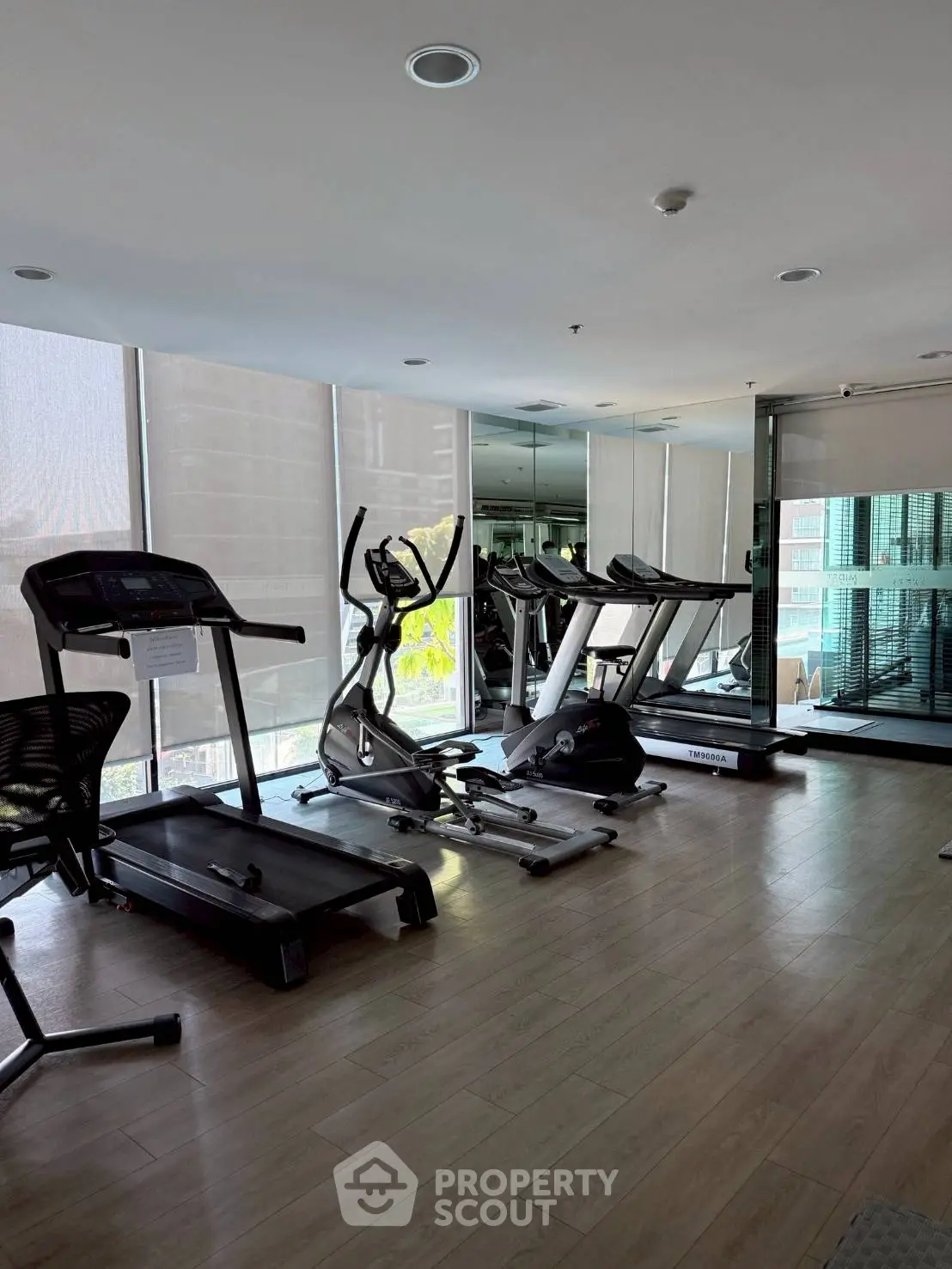 Modern gym with treadmills and exercise equipment in a high-rise building.