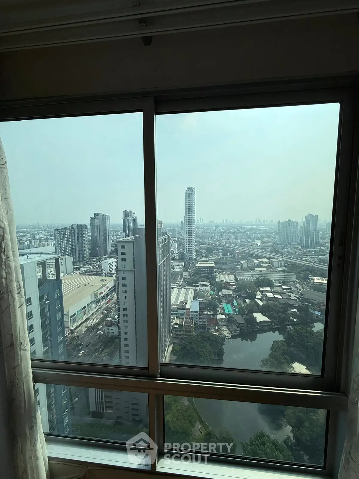 Stunning cityscape view from high-rise apartment window showcasing urban skyline.