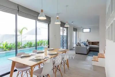 Modern open-plan living and dining area with pool view, stylish furniture, and abundant natural light.