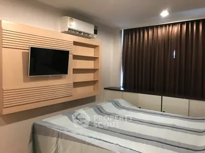 Cozy bedroom with modern decor, featuring a wall-mounted TV and air conditioning, perfect for relaxation.