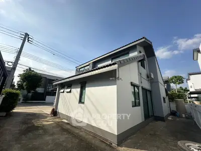 Modern two-story house with sleek design and spacious driveway in a serene neighborhood.